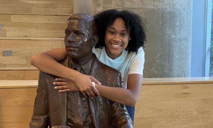 Deanna Yancey hugging 'The First Graduate' statue of her grandfather.