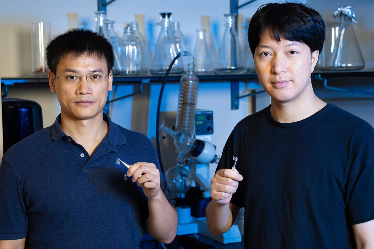 Mingzhe Li, left, and Liang Yue holding small pieces of the raw material they use to 3D print glass microstructures. (Photo: Candler Hobbs)