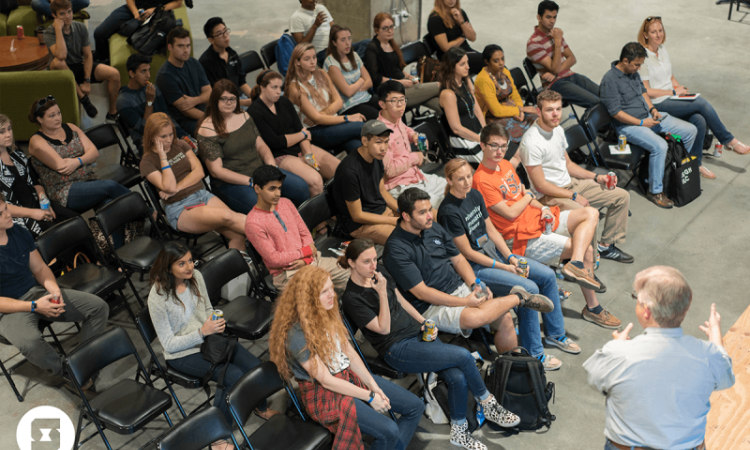 Students seated listening to a speaker, photo