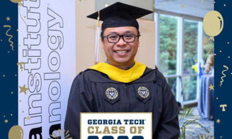 Student posing in front of graduation signs, photo