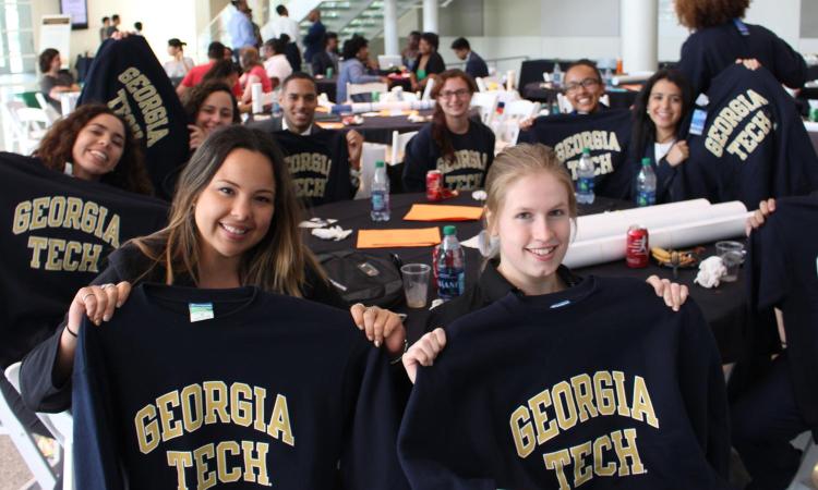 Students holding sweatshirts