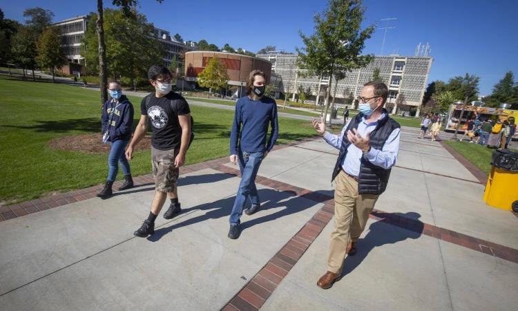 Professor Bernard Kippelen walks outside with students