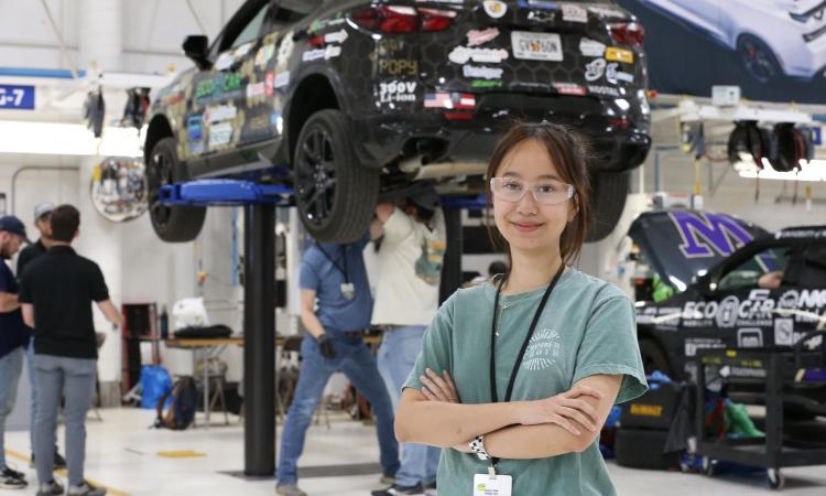 student in front of car