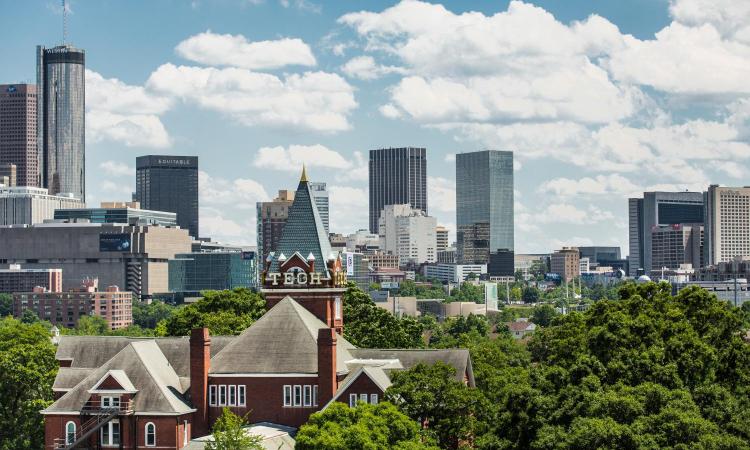 Tech Tower poking through the treeline, with Atlanta skyline in the background.