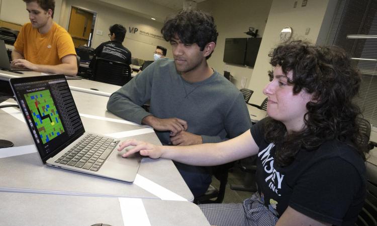 two VIP students working on a laptop