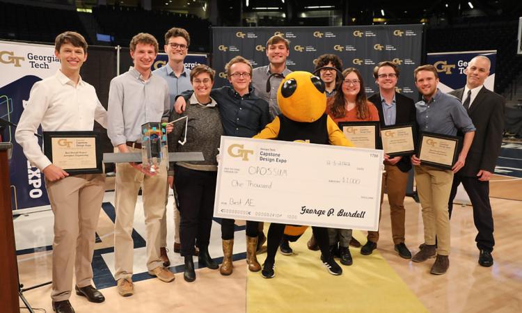 The winning AE team OPOSSUM with Buzz and a check