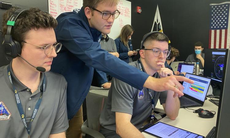 Students pointing and looking at computer