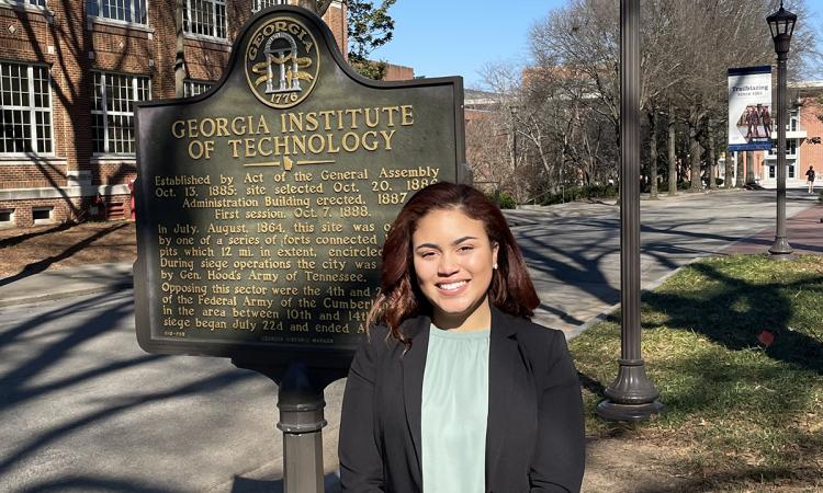 Sydney Mudd poses in front of the Georgia Tech historical marker in Harrison Square.