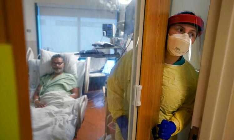 Registered nurse Rachel Chamberlin steps out of an isolation room where Fred Rutherford recovers from COVID-19 at Dartmouth-Hitchcock Medical Center, in Lebanon, N.H., Jan. 3, 2022.