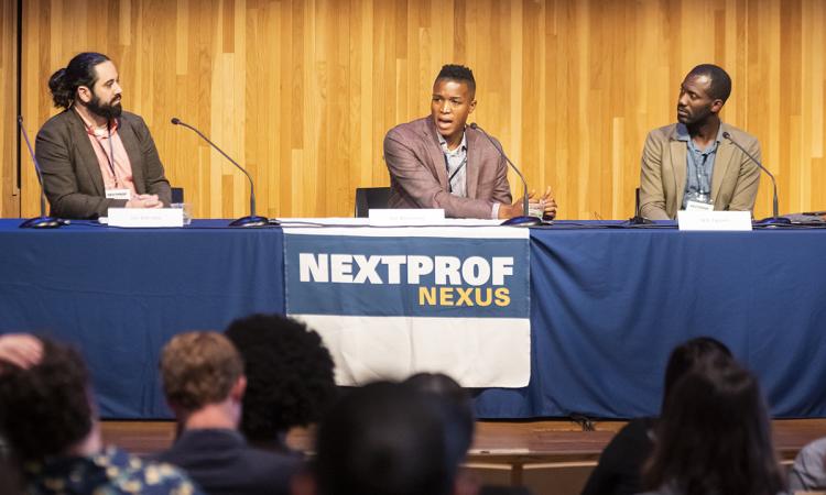 Three people sitting at a table with NextProf banner