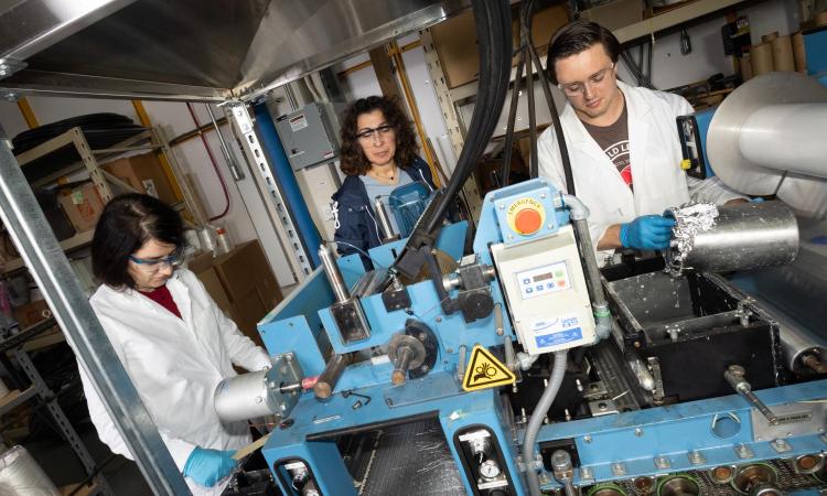 three people looking at lab equipment