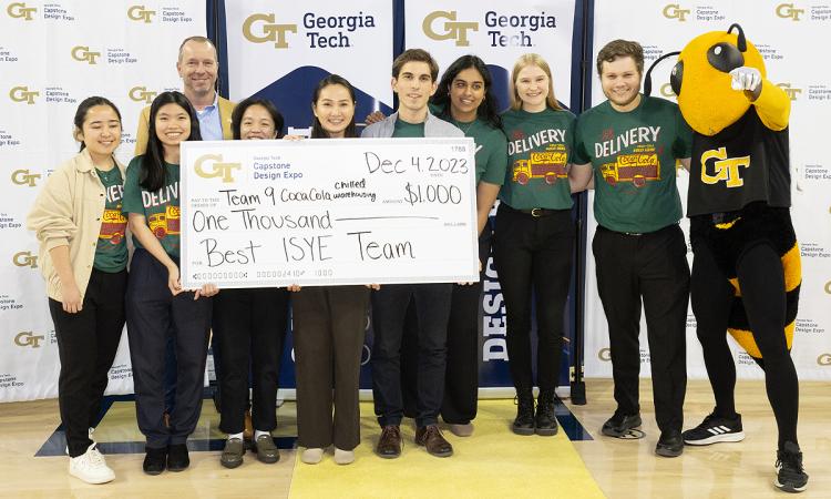 The winning ISyE team with an oversized check, Buzz, and School Chair Edwin Romeijn