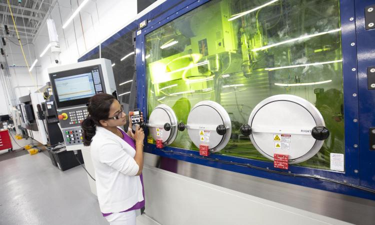 A woman uses manufacturing equipment in the AMPF