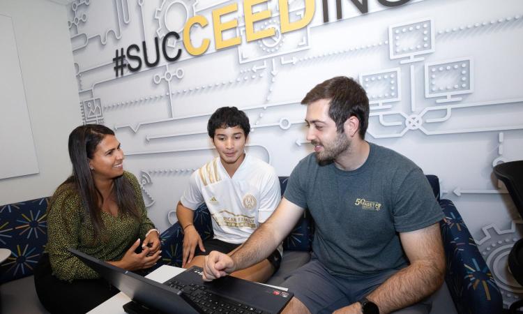 Three people talking at a table in the CEED office