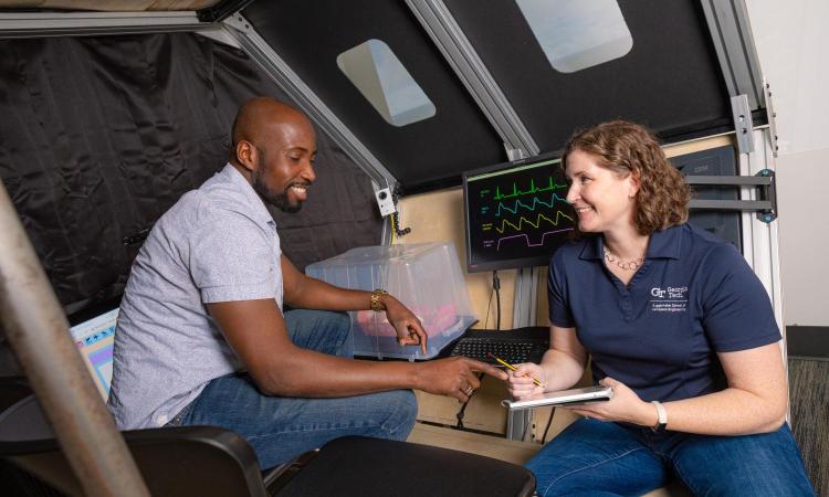 Ph.D. student Richard Agbeyibor, left, and Professor Karen Feigh prepare for a round of tests in their custom-designed medevac simulator.