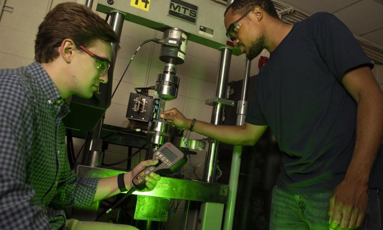 Two people work with lab equipment