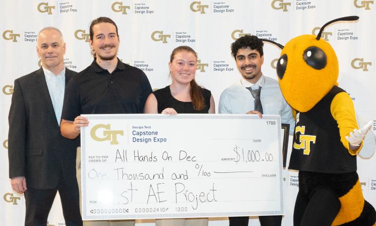 a group of people and Buzz stand with an oversized check