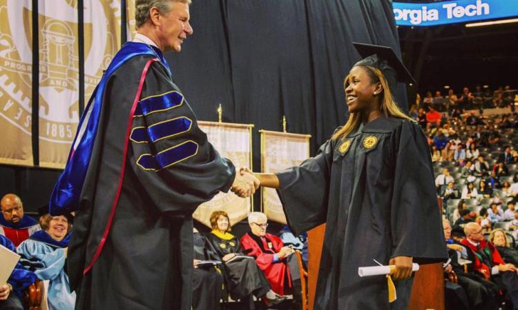 graduate shakes hand at graduation