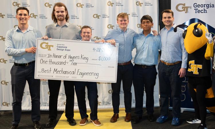 a group of people with an oversized check and Buzz