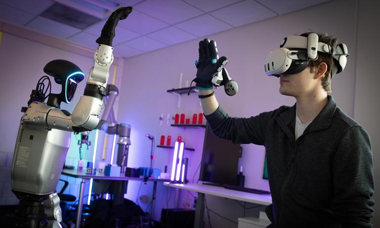 a human with virtual reality gear interacts with a humanoid robot