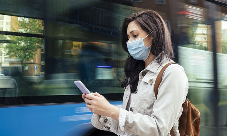 image of someone using a smartphone at a bus stop