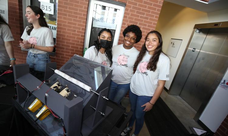 Three students with clothing machine