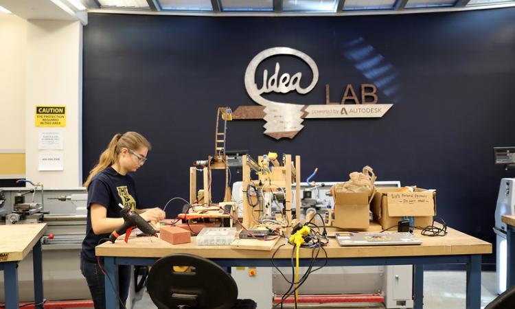 student working at a machine in the ideas lab