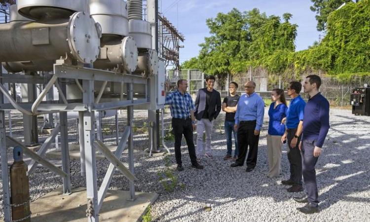 The research team looks at a high-voltage circuit breaker