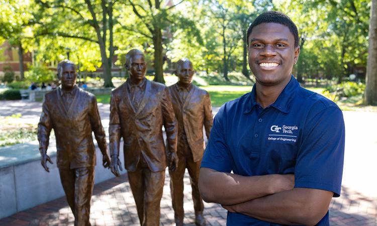 Dean's Scholar Gideon Ndeh on the Georgia Tech campus in front of the Trailblazers statue at Harrison Square