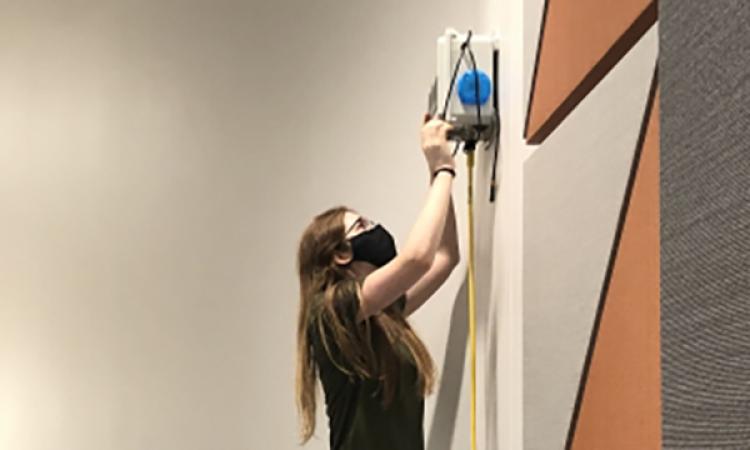 ChBE PhD student Sabrina Westgate installs an air sensor to monitor classroom air quality.