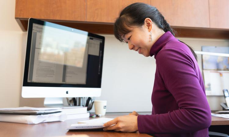 Iris Tien looking at papers on her desk