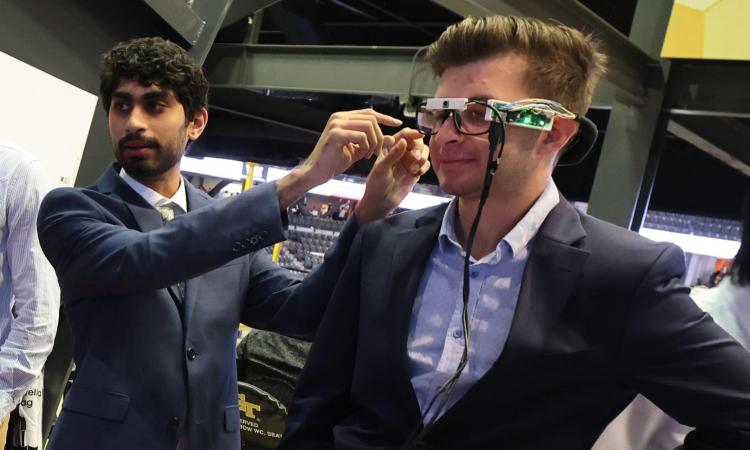 two people demonstrate a wearable device to help visually impaired individuals