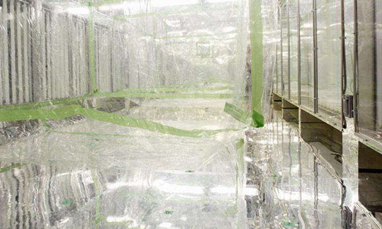 Sheets of transparent plastic and green tape hang from the ceiling in a bright, silvery room. The Georgia Tech Environmental Chamber facility was used to study oxidation chemistry and secondary organic aerosol formation in multi-precursor systems.