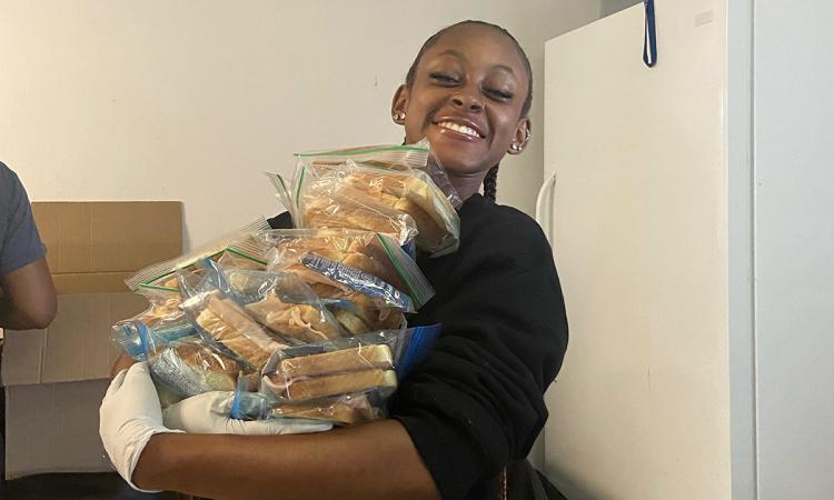 Jordine Jones with an armful of sandwiches in resealable bags.