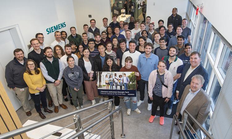 Georgia Tech students enrolled in Electric Vehicles & the Grid stop to pose with Siemens employees during a class visit to the Peachtree Corners office.