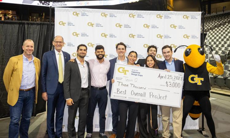 winning team with faculty, standing with oversized check and Buzz mascot