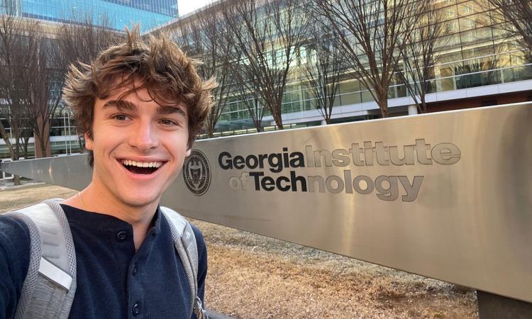 Survivor contestant and Georgia Tech student Carson Garrett with the Georgia Tech sign in Tech Square.