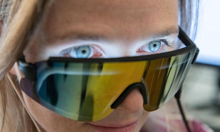 Closeup of Annabelle Singer wearing special glasses with flickering lights inside shining on her eyes. (Photo: Allison Carter)