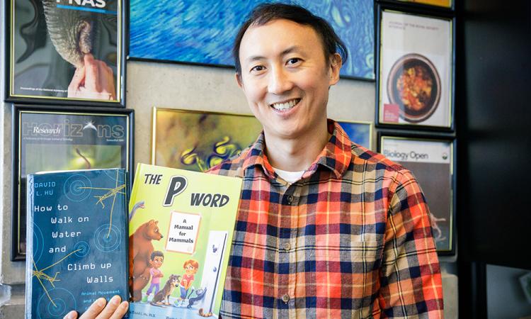 David Hu holding two books, "How to Walk on Water and Climb up Walls" and "The P Word."