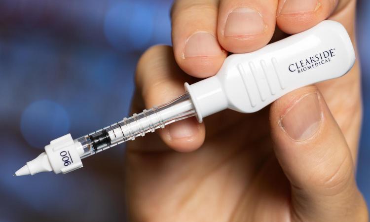 a hand holding a microneedle device used for eye injections