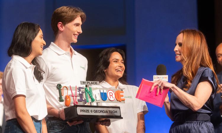 Three students of Team Lilypad with the first place trophy and host Faith Salie