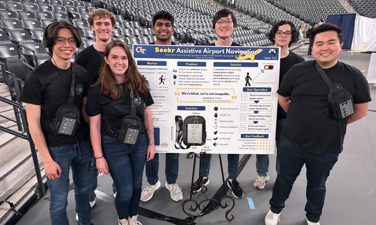 students posing with devices and poster