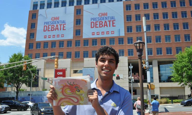 Alec Grosswald holds up a copy of the 'Technique' outside the Warner Media campus prior to the June 2024 presidential debate.