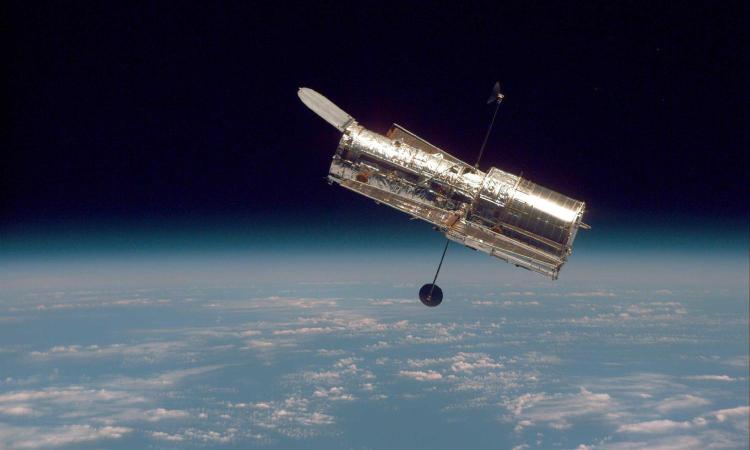 The Hubble Space Telescope hovers at the boundary of Earth and space in this picture, taken after Hubble second servicing mission in 1997.