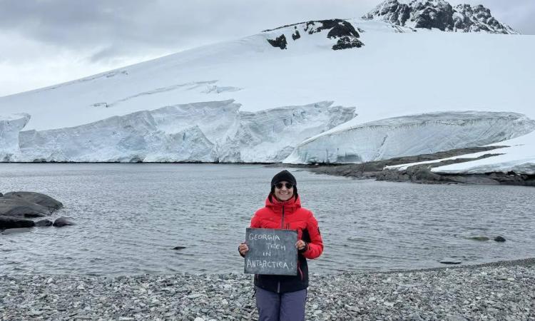 Ph.D. candidate Shweta Dutta in Horseshoe Island, Antarctica holding a handmade sign reading "Georgia Tech in Antarctica."