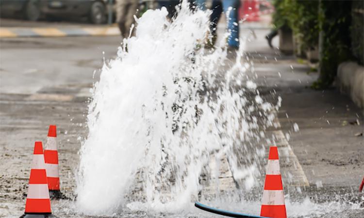 cones surround water spewing from a broker underground water pipe