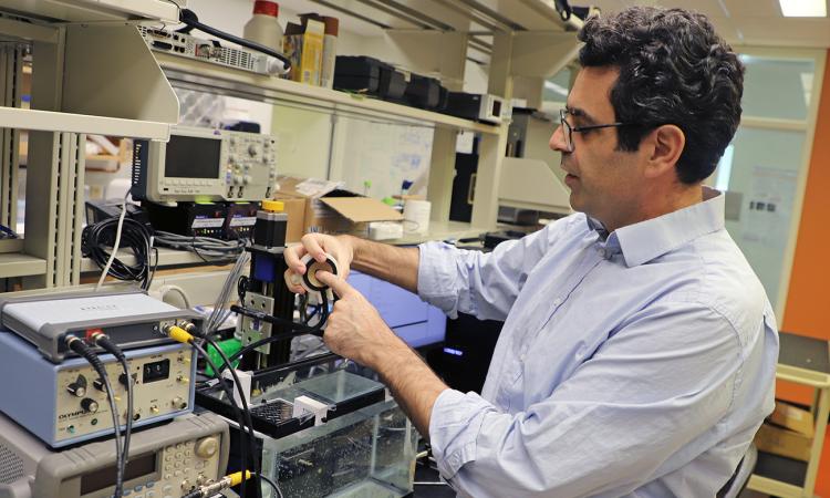 Costas Arvanitis in the lab with equipment his team uses to create and vibrate microbubbles. (Photo: Jerry Grillo)