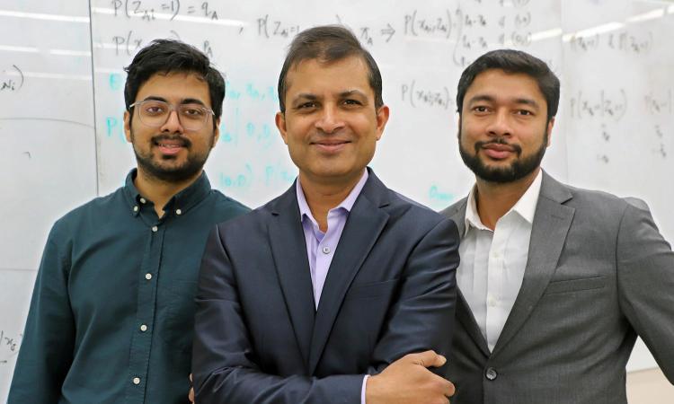 Three men, Bhavay Aggarwal, Saurabh Sinha, and Anurendra Kumar, stand in front of a white board with formulas written on it.