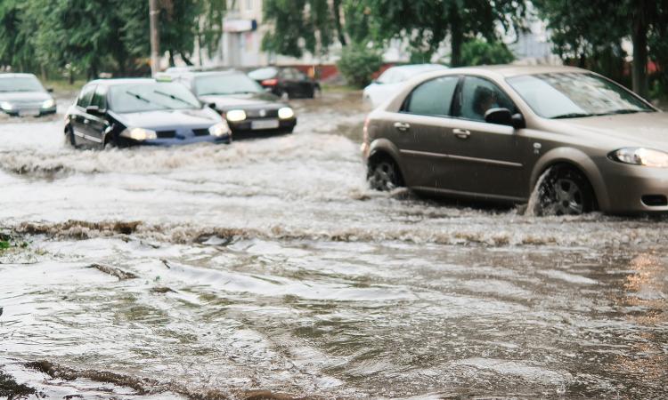 stock image of cars driving in a flooded street