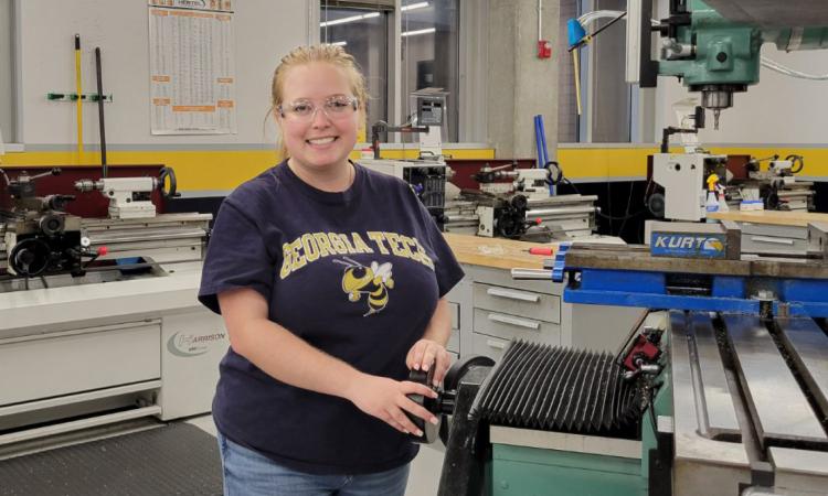 Harley Fuller stands next to a machine in the Montgomery Machining Mall.